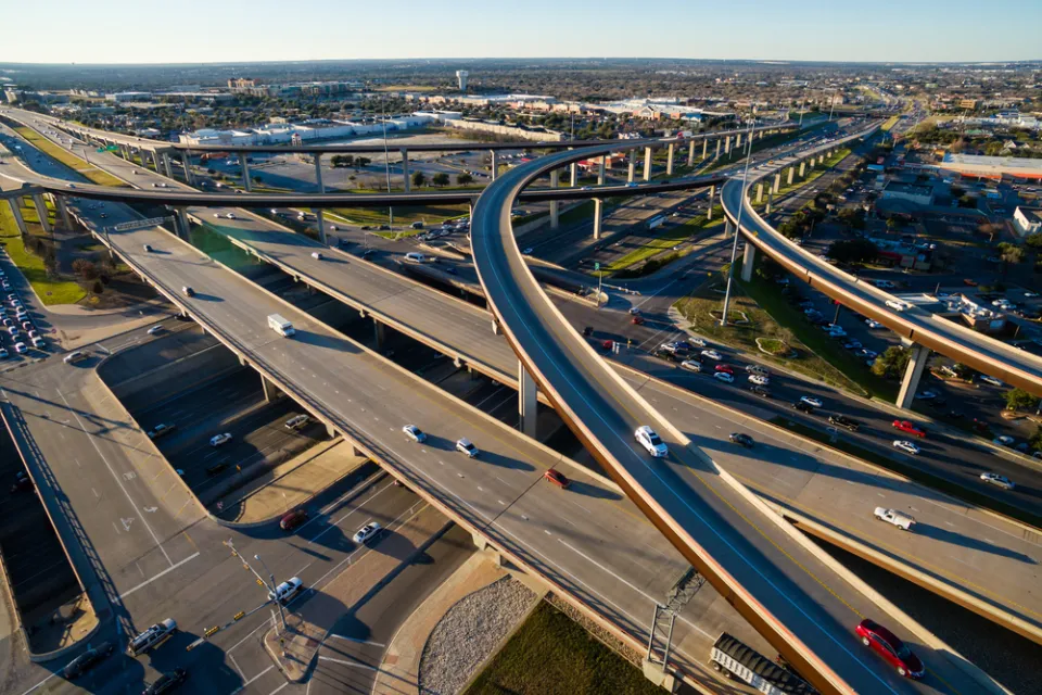 Aerial Texas Hill Country at sunset, with an aerial view of a highway interchange and Interstate 35 in Austin, Texas.